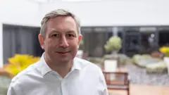 "They are essential" describes how smoke detectors are changing. 17 Fireangel Wearing a smart, white shirt, Nick Rutter smiles at the camera.