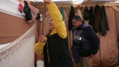 Um Shadi shows Adnan El-Bursh how she keeps rainwater from accumulating on the roof of her tent