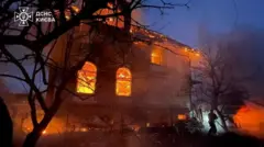 Reuters A firefighter works at a residential building that is ablaze