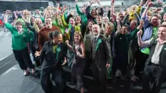 Getty Images A large group of Green MSPs and supporters celebrating their wins in the Glasgow election count hall.