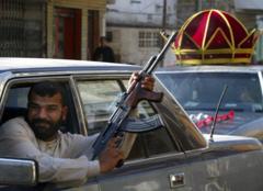 arabadan silahla havaya ateş eden bir erkek