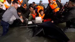 Young girl cries on an inflatable boat packed with migrants