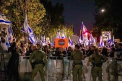 25 Kasım'da Netanyahu'nun evinin önünde düzenlenen gösteride bir protestocu "Terk edildik" yazılı bir pankart tutuyor