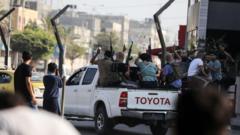 Combatientes de Hamás regresan a la Franja de Gaza en una camioneta con fusiles en el aire