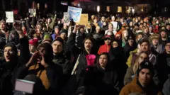 Reuters/Tim Evans In the dark, a photo taken from above shows a large group of people wearing heavy coats and carrying signs.