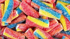Rainbow sour jelly candy covered in sugar sprinkles