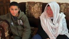 Karim sitting on a sofa next to his grandmother