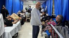 Patients lying on portable beds in a hallway inside Al-Shifa hospital