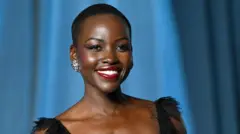 Lupita Nyong'o smiling and wearing a black dress, posing for photos at the Academy Museum of Motion Pictures in Los Angeles in October 2025