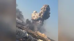A large plume of smoke rises to the sky