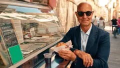 Stanley Tucci holding lampredotto in Florence