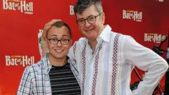 Getty Joe with his father Joe on a red carpet. They are both smiling and looking to the camera.