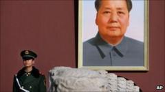 Soldier stands in front of a portrait of Mao Zedong in Tiananmen Square in Beijing