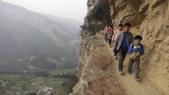 Students walking to school on narrow paths along the side of a mountain in China