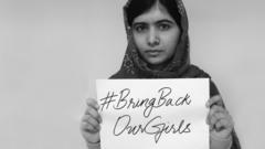 Malala Yousafzai holds up a sign saying Bring Back Our Girls