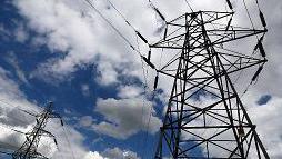 Two electricity pylons against a cloudy sky