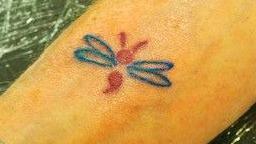 A butterfly tattoo where a semi colon has replaced the body of the butterfly.