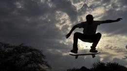 Homem faz manobra de skate no ar