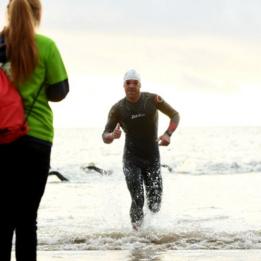 Homem sai do mar após horas de natação