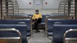A passenger is seen wearing a protective mask as a precaution from coronavirus in the local train at CST railway station, on March 14, 2020 in Mumbai, India.