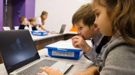 Niños en clase con una computadora.