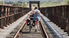 Pushing a bike across a railway bridge