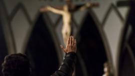Hombre frente a Cristo levantando la mano
