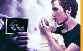 Freddy McConnell holding his baby and pregnancy scan