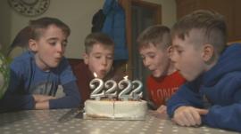 Four children blow out birthday candles