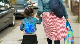 Mother and daughter walking to school stock photo