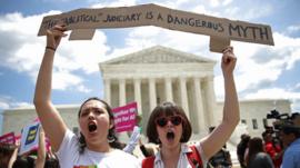Protesters gather outside the US Supreme Court following a court issued immigration ruling 26 June
