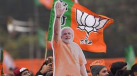 Bharatiya Janta Party (BJP) supporters wave party flags during a rally by Prime Minister Narendra Modi along with other party leaders, at Ramlila Ground on December 22, 2019 in New Delhi, India.