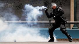 A police officer throws a tear gas canister during protests in Quito, Ecuador, 7 October, 2019.
