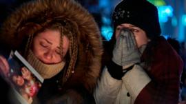 Two women cry during vigil for Canadian victims of Iran air crash