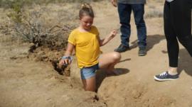 Una niña que vive en Ridgecrest introduce su pierna en la grieta creada tras el terremoto.