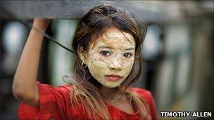 Bajau girl, her face covered in rice paint for sun protection