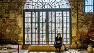 A woman sits at the exhibition of Bangladesh at the 16th Venice Biennale in Venice