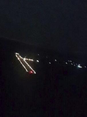 Pista aérea iluminada por faróis de carro