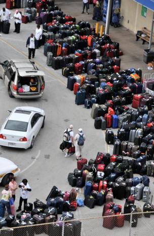 Hundreds of suitcases are are placed on the ground ready to be loaded onto a ship