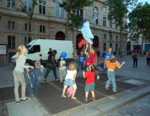 Children gather and watch as their jackets fly over the subway vents