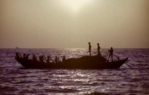 Fishermen row in the sea on a cloudy day