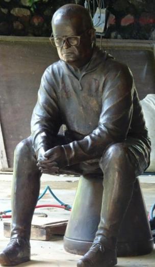 Escultura de Marcelo Bielsa sentado sobre un balde.