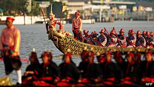 Thai Royal navy oarsmen in ancient warrior costume row the Royal barge on the Chao Phraya river during the Royal celebrations in 2007