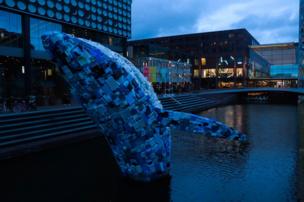 A whale sculpture is made out of plastic