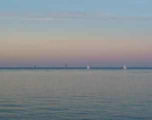 Yachts sail past in the distance
