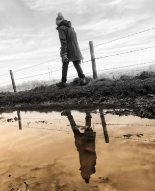 Woman passing a puddle
