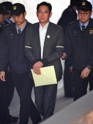 Lee Jae-yong esposado y escoltado por policías en 2017