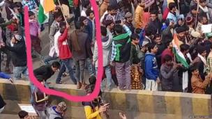 विरोध प्रदर्शन के दौरान हाथ में झंडा लिए हुए आमिर हंज़ला