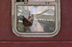 Man man looks through a broken window in Sri Lanka