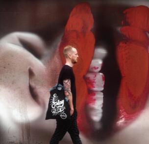 A man walks past graffiti